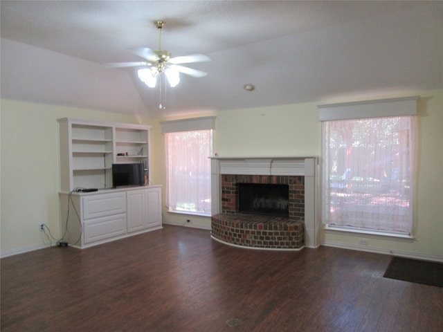 unfurnished living room with ceiling fan, dark hardwood / wood-style floors, vaulted ceiling, and a brick fireplace