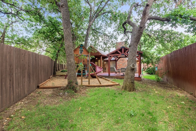 view of yard featuring a deck and a playground