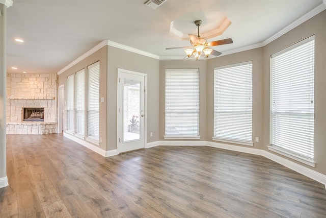 unfurnished living room featuring visible vents, crown molding, a fireplace, and wood finished floors