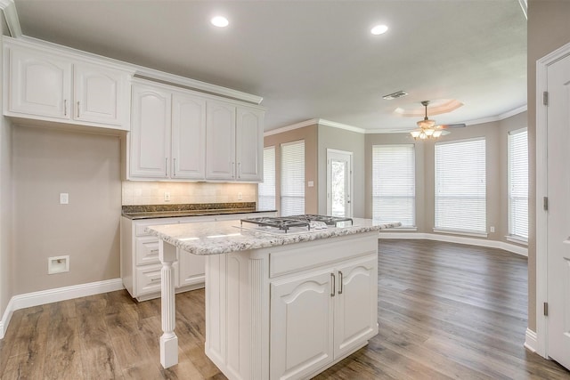 kitchen featuring visible vents, a kitchen island, and white cabinetry