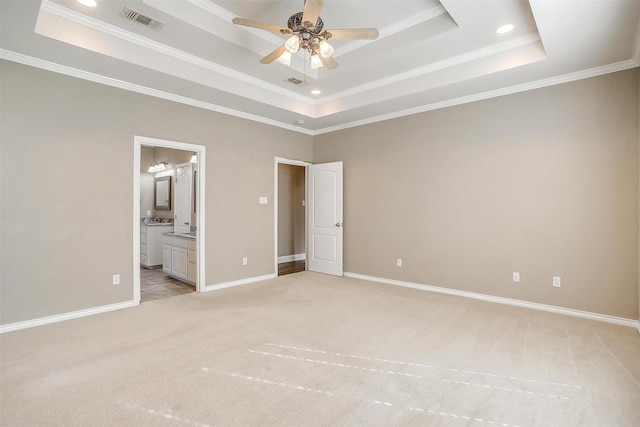 unfurnished bedroom with light colored carpet, a raised ceiling, visible vents, and baseboards