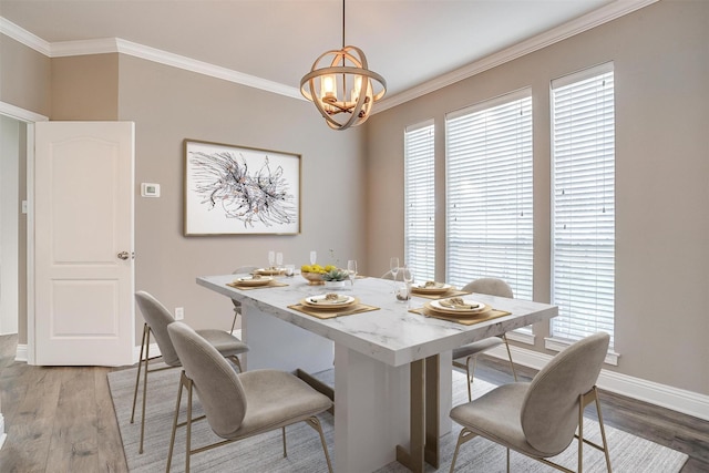 dining room with a chandelier, wood-type flooring, and ornamental molding