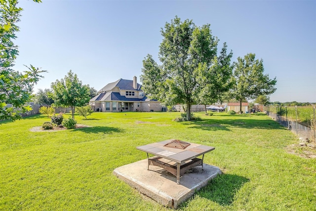 view of yard featuring a patio area, a fenced backyard, and an outdoor fire pit