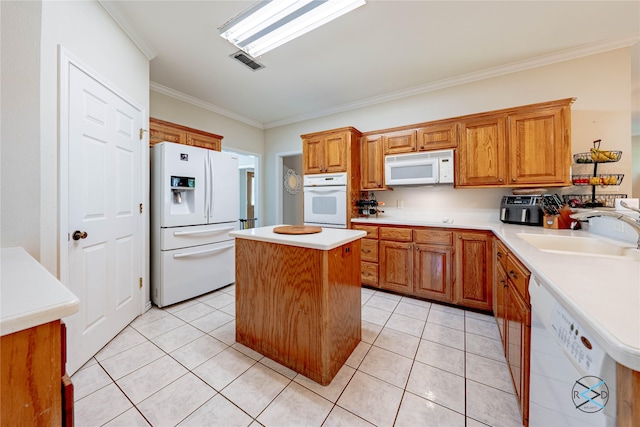 kitchen featuring ornamental molding, white appliances, sink, light tile patterned floors, and a kitchen island