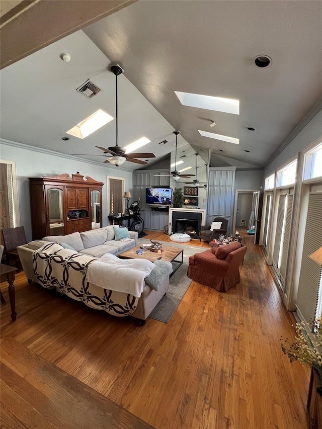 bedroom featuring hardwood / wood-style floors, ornamental molding, and lofted ceiling with skylight