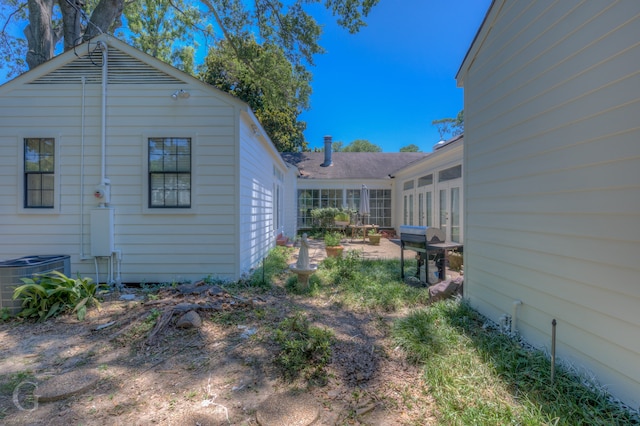 view of side of home with central AC