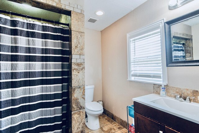 bathroom with vanity, toilet, and walk in shower