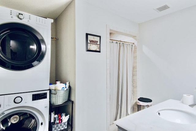 laundry area with sink and stacked washer / dryer