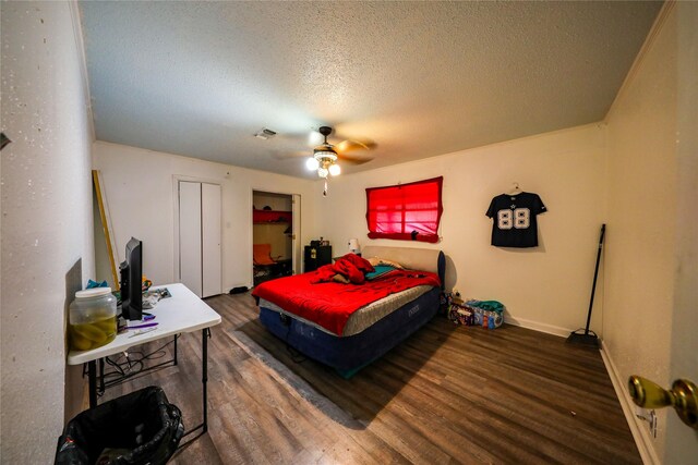 bedroom featuring dark hardwood / wood-style floors, ceiling fan, a closet, and a textured ceiling