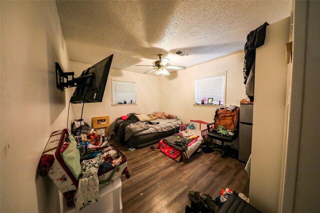 bedroom with ceiling fan, a textured ceiling, and hardwood / wood-style flooring