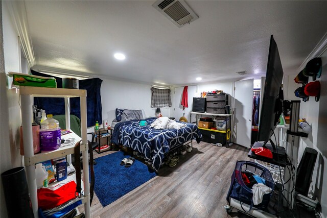 bedroom with crown molding and hardwood / wood-style floors