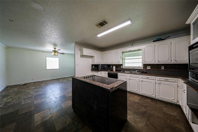 kitchen with dark tile floors, white cabinetry, and black appliances