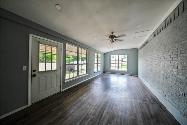 interior space featuring brick wall, dark hardwood / wood-style flooring, ceiling fan, a textured ceiling, and lofted ceiling