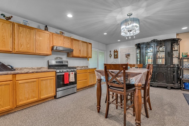 kitchen featuring decorative light fixtures, light colored carpet, and stainless steel gas range