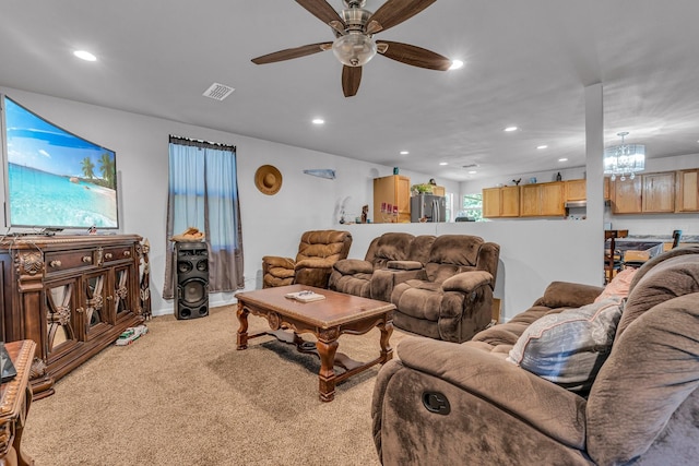 living room featuring ceiling fan with notable chandelier and carpet floors