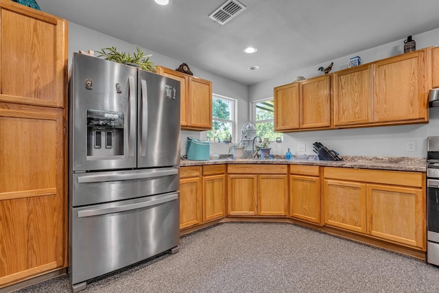 kitchen with sink, light stone counters, ventilation hood, stainless steel fridge, and light carpet