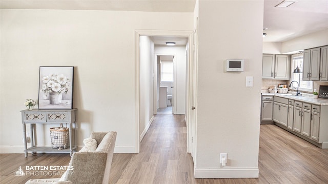 hallway with light hardwood / wood-style floors and sink