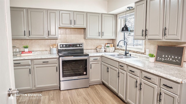 kitchen with decorative light fixtures, decorative backsplash, sink, light hardwood / wood-style floors, and stainless steel electric range