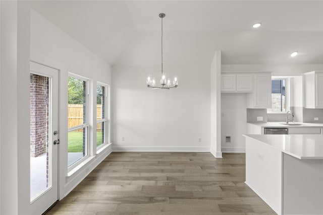 kitchen featuring white cabinetry, hardwood / wood-style floors, sink, and vaulted ceiling