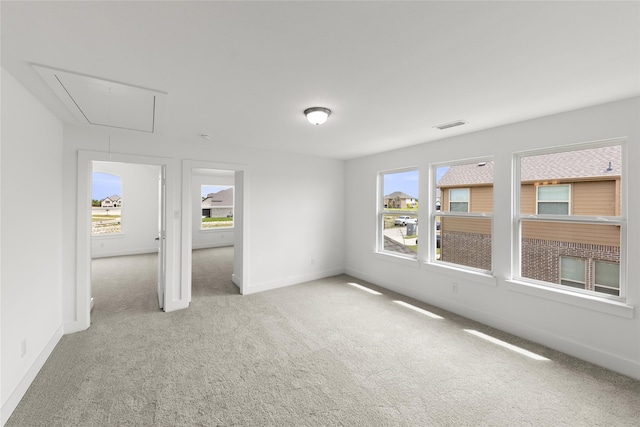 empty room with a wealth of natural light and light carpet