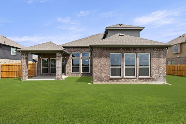 rear view of property with a lawn and a patio