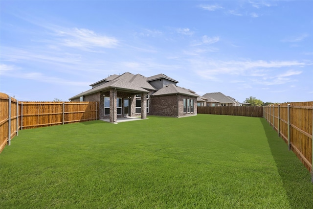 rear view of house featuring a yard and a patio area