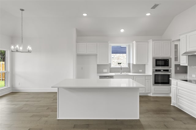 1727 Newport Dr, Cedar Hill, TX 75104 - kitchen featuring appliances with stainless steel finishes, a sink, vaulted ceiling, tasteful backsplash, and white cabinetry