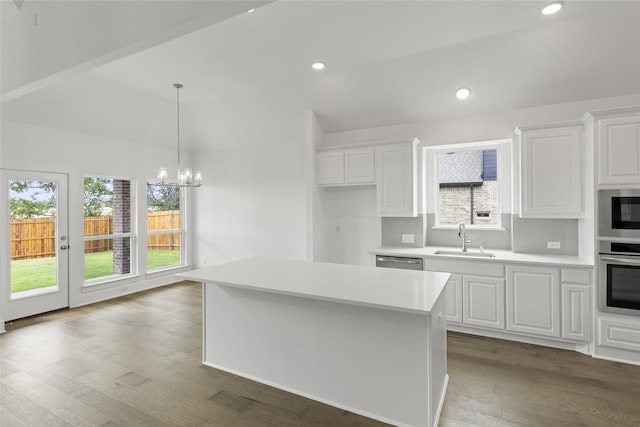 kitchen with white cabinets, stainless steel appliances, sink, and a center island