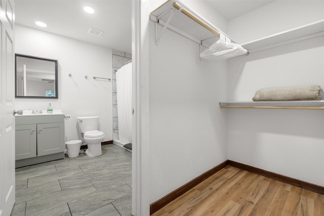 bathroom featuring vanity, wood-type flooring, curtained shower, and toilet