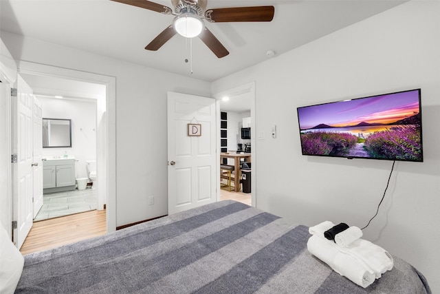 bedroom featuring ceiling fan, connected bathroom, and light colored carpet