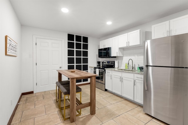 kitchen with white cabinetry, appliances with stainless steel finishes, sink, and backsplash