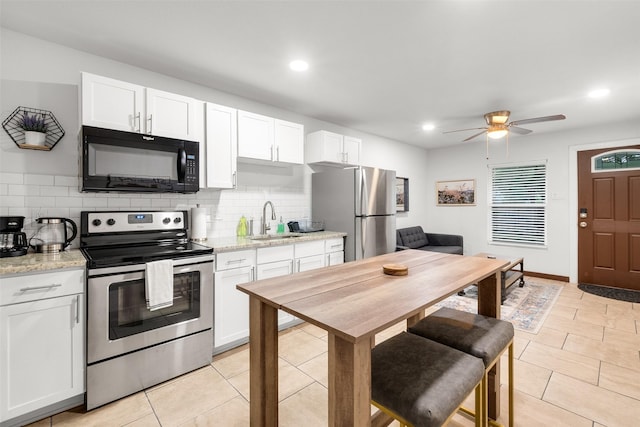 kitchen featuring backsplash, appliances with stainless steel finishes, sink, and white cabinets