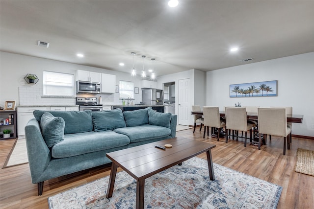 living room with sink and light hardwood / wood-style floors