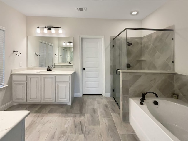 bathroom featuring separate shower and tub and vanity