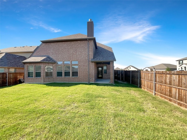 rear view of property featuring a lawn