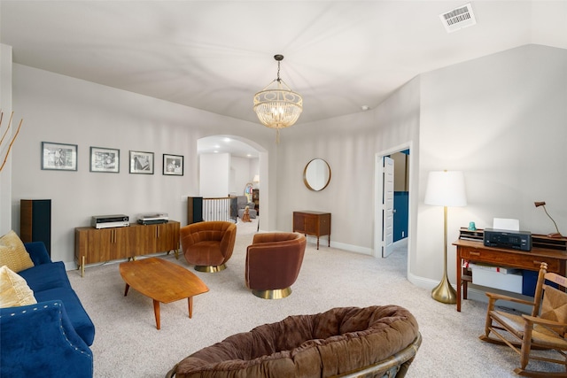 living area with arched walkways, light colored carpet, visible vents, baseboards, and an inviting chandelier