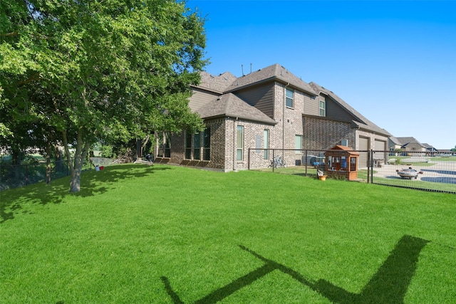 exterior space with a fenced backyard, a lawn, and brick siding