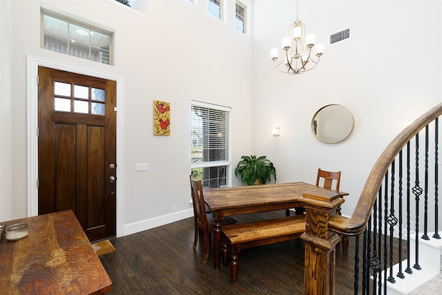 dining area featuring visible vents, a towering ceiling, stairway, dark wood-style flooring, and a notable chandelier