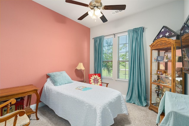 carpeted bedroom featuring a ceiling fan, visible vents, and baseboards