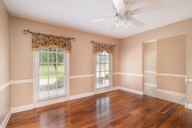 unfurnished room featuring ceiling fan, wood-type flooring, and a textured ceiling