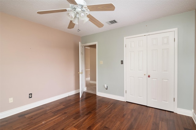 unfurnished bedroom with ceiling fan, dark hardwood / wood-style flooring, and a textured ceiling