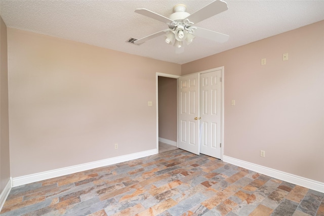 empty room featuring ceiling fan and a textured ceiling