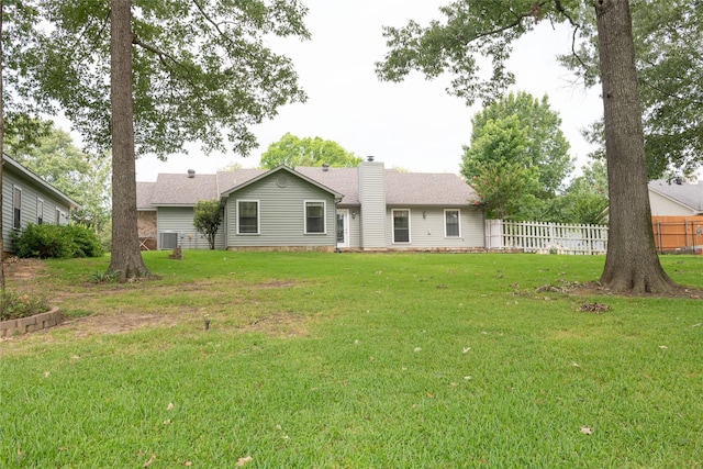 back of property with cooling unit and a lawn