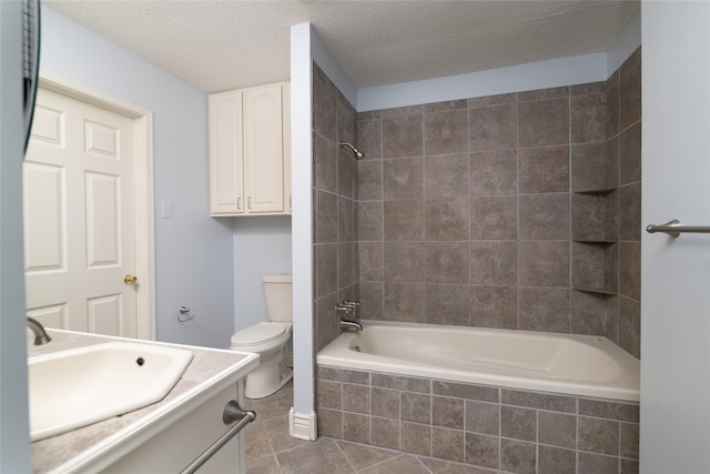 full bathroom with tile patterned floors, vanity, a textured ceiling, toilet, and tiled shower / bath