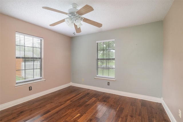 unfurnished room with a textured ceiling, plenty of natural light, and dark hardwood / wood-style floors