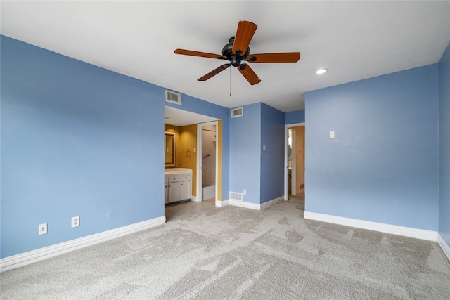 unfurnished bedroom featuring ensuite bath, ceiling fan, and light colored carpet