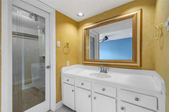 bathroom with walk in shower, vanity, tile patterned floors, and ceiling fan