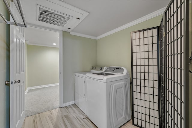 washroom featuring light carpet, washer and clothes dryer, and crown molding