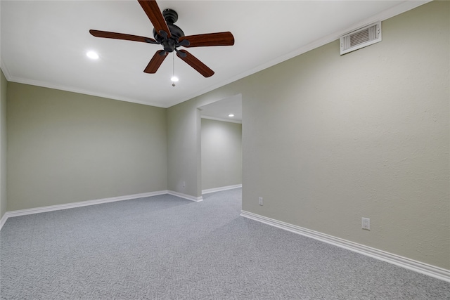 carpeted spare room featuring ceiling fan and ornamental molding