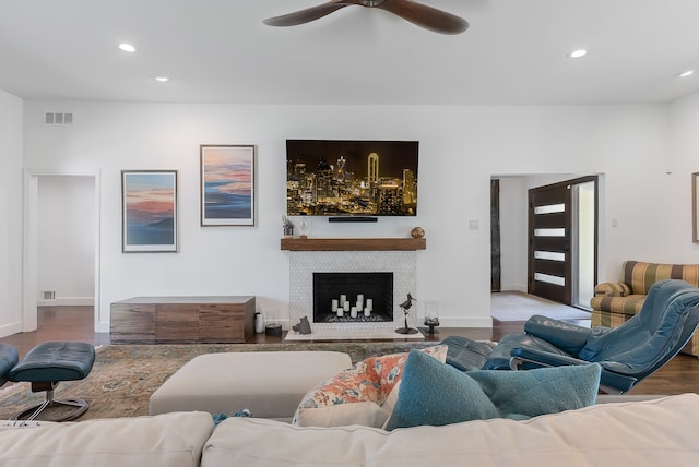 living room featuring a tile fireplace, ceiling fan, and hardwood / wood-style flooring